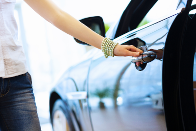 new car with woman standing in dealer showroom